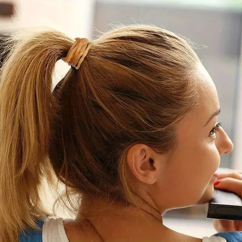 Hair elastic band in yellow securing a ponytail; durable natural rubber.