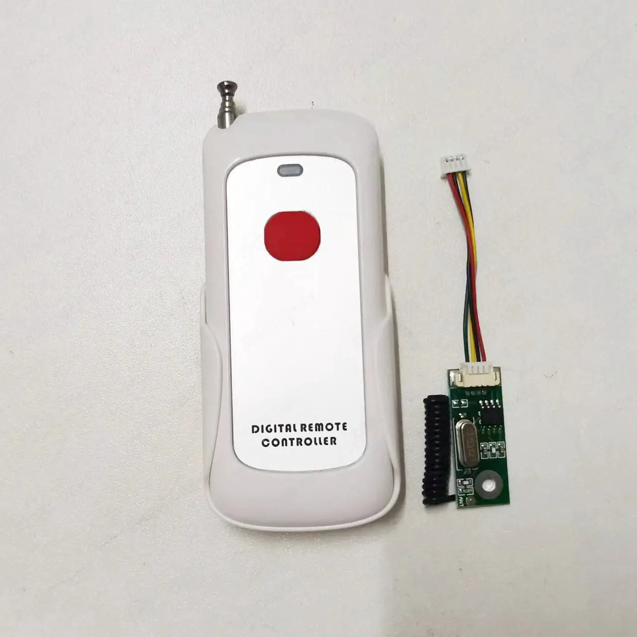 White digital remote controller with a red push button and a separate wired circuit board