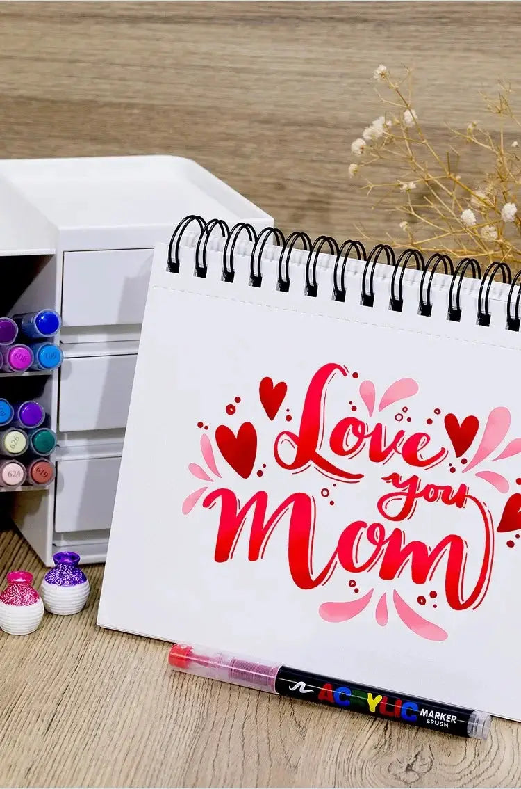 GUANGNA 16-color direct-liquid acrylic paint pen set displayed beside a calendar page reading Love You Mom