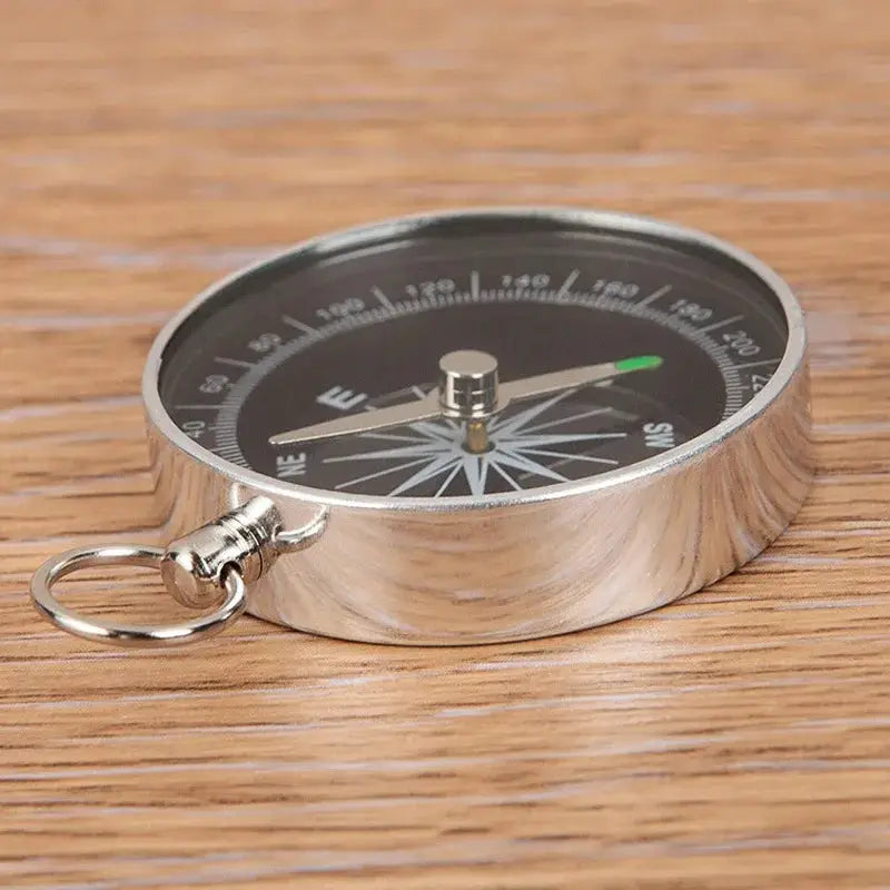 Mini aluminum compass keychain pendant by Simples Market; portable survival compass with silver body and black dial