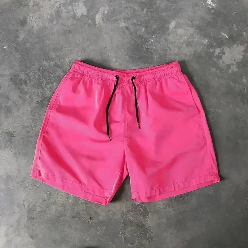 Men's pink swim shorts by Simples Market with black drawstring and elastic waist.