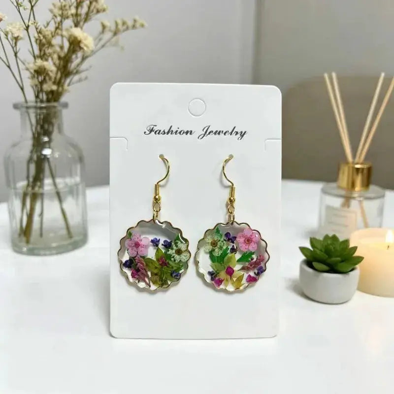 Simples Market pressed flower epoxy resin earrings with scalloped round pendants and gold-tone hooks.