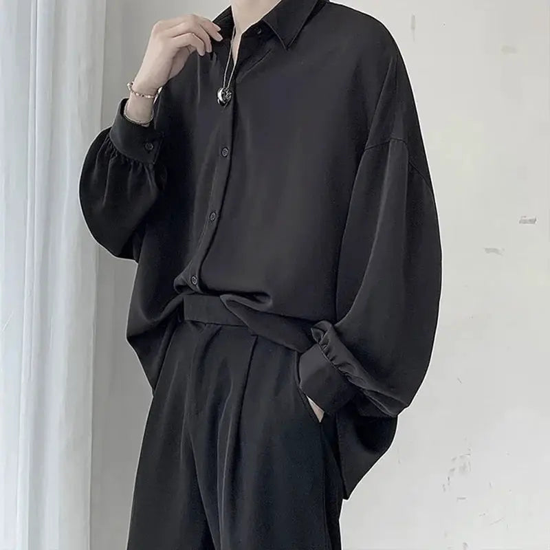 Black oversized men's long-sleeve shirt with button front paired with matching relaxed trousers, casual loungewear set.