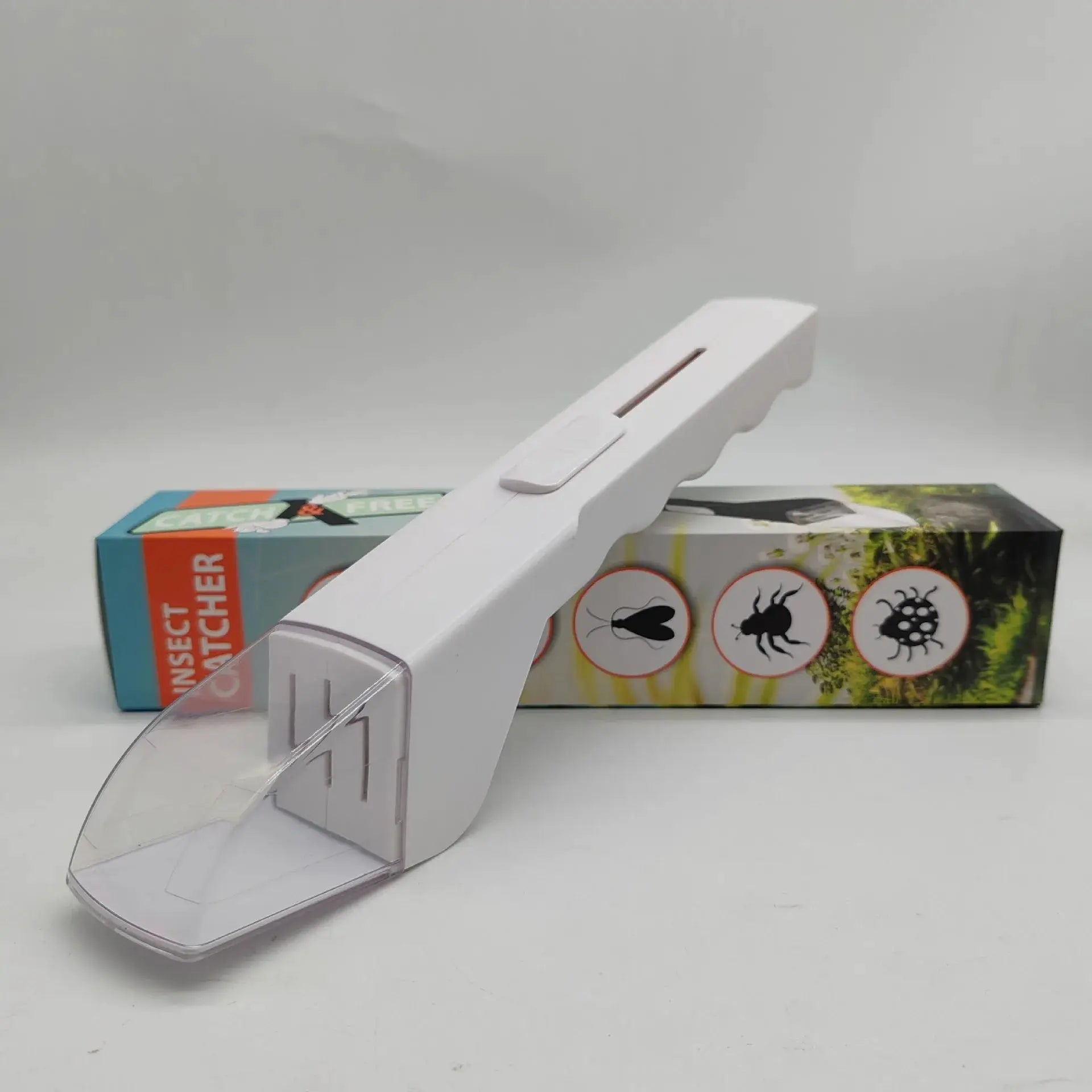 Handheld insect catcher in white plastic with a transparent curved scoop, background shows insect-box art