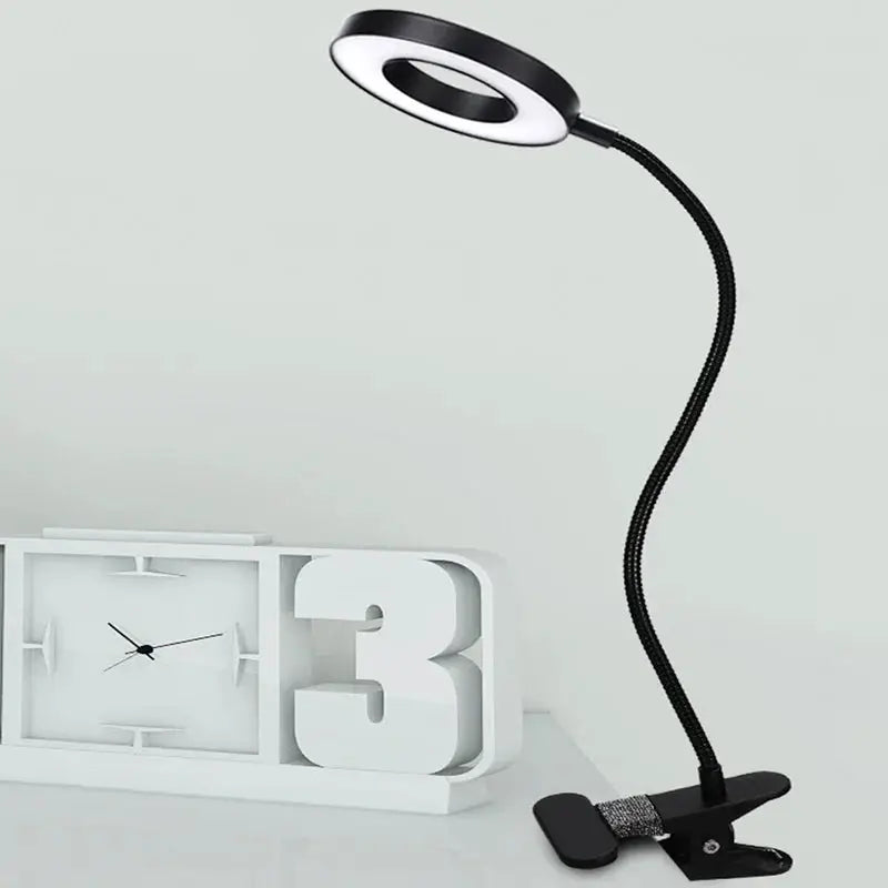 LED Ring Clamp Lamp with flexible gooseneck and clamp base; black neck, white ring.