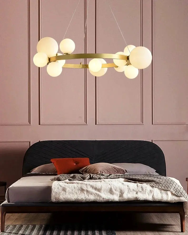 Gold circular chandelier with frosted glass globes, an indoor hanging light for living room or bedroom.