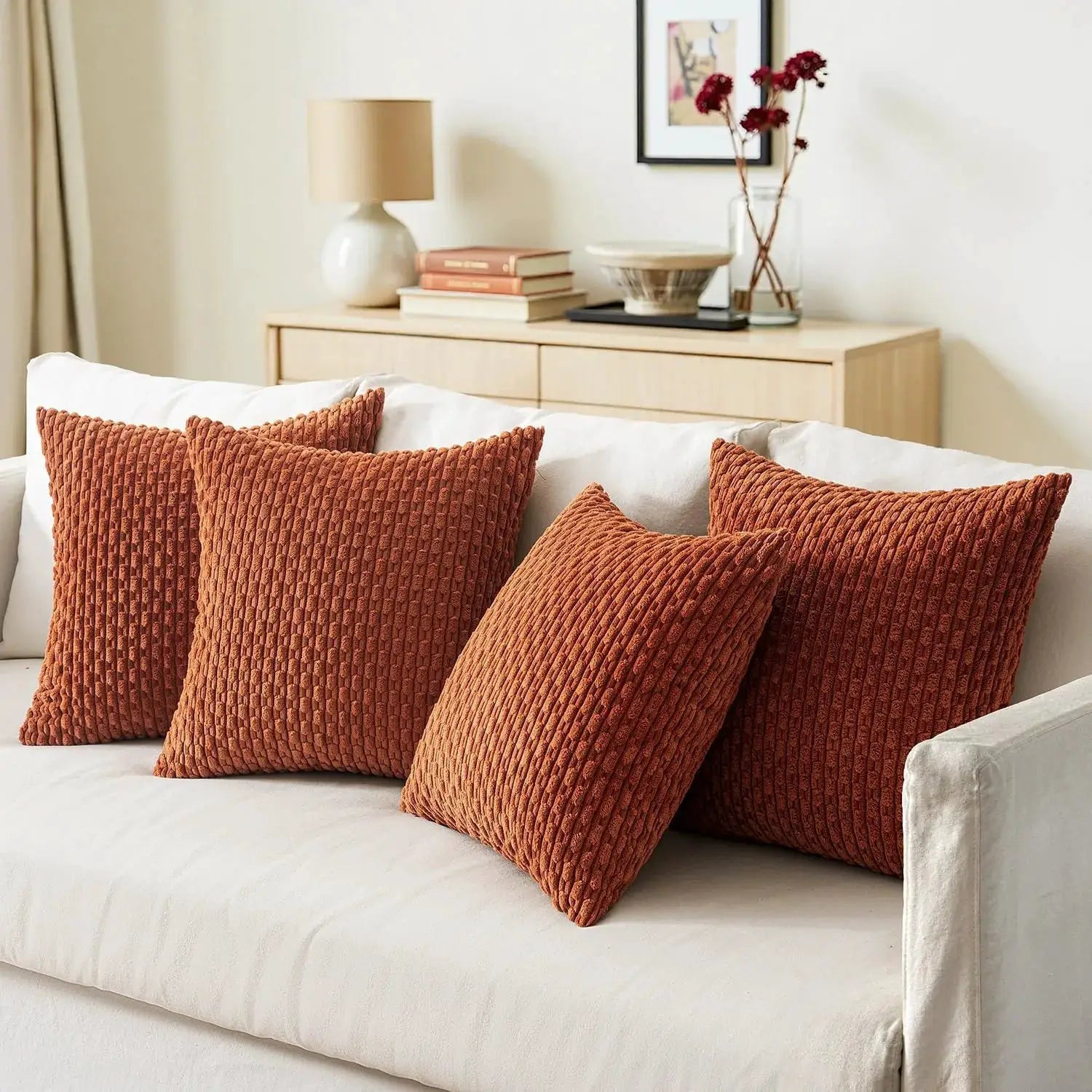 Three rust-orange corduroy throw pillows, 20x20 inches, farmhouse style on a white sofa