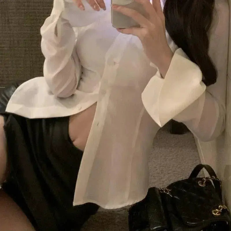 White women's blouse with flared sleeves, lapel, and single-breasted front.