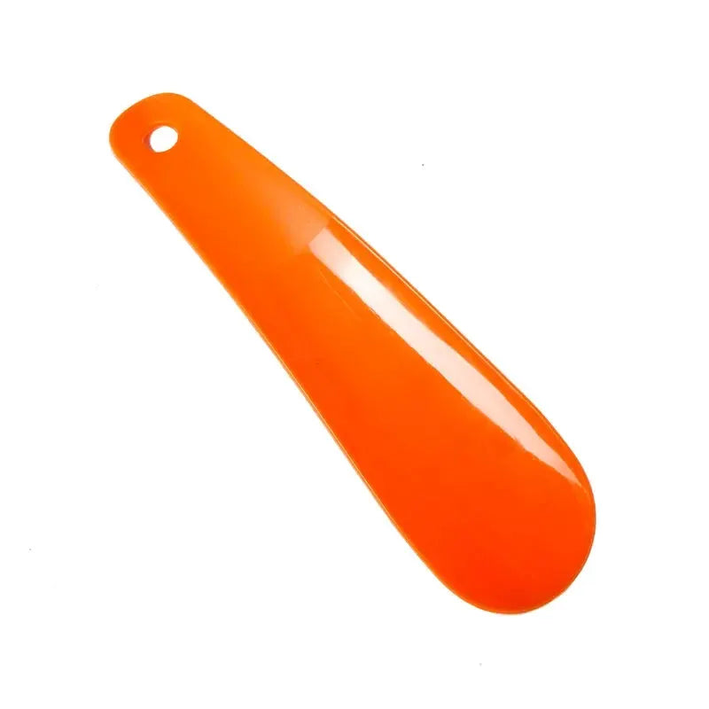 Orange plastic shoe horn, 16 cm long with hanging hole