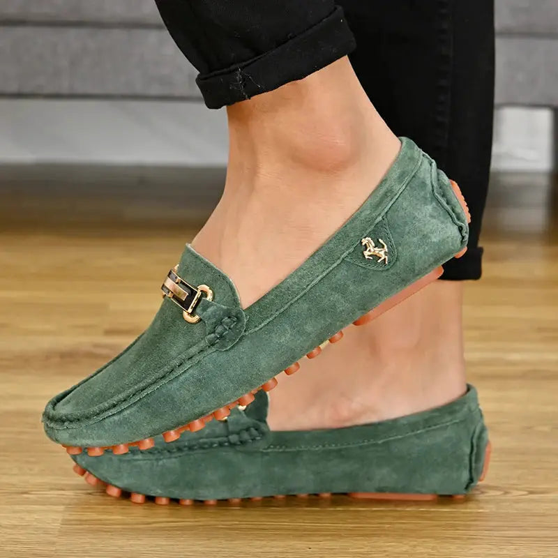 Pair of green suede driving loafers for men with gold hardware and tan outsoles