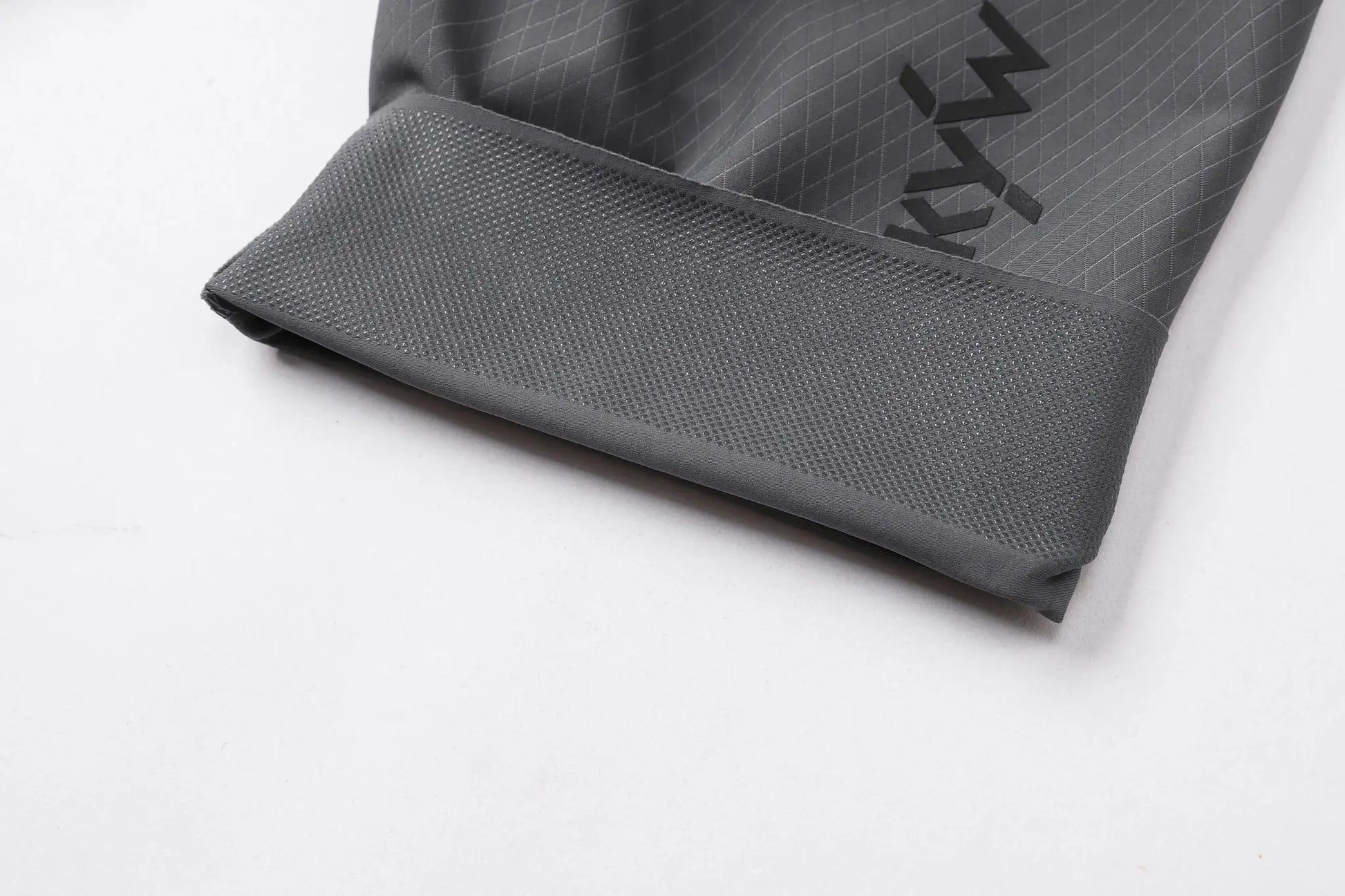 Gray cycling bib shorts close-up showing diamond-grid fabric and knit cuff