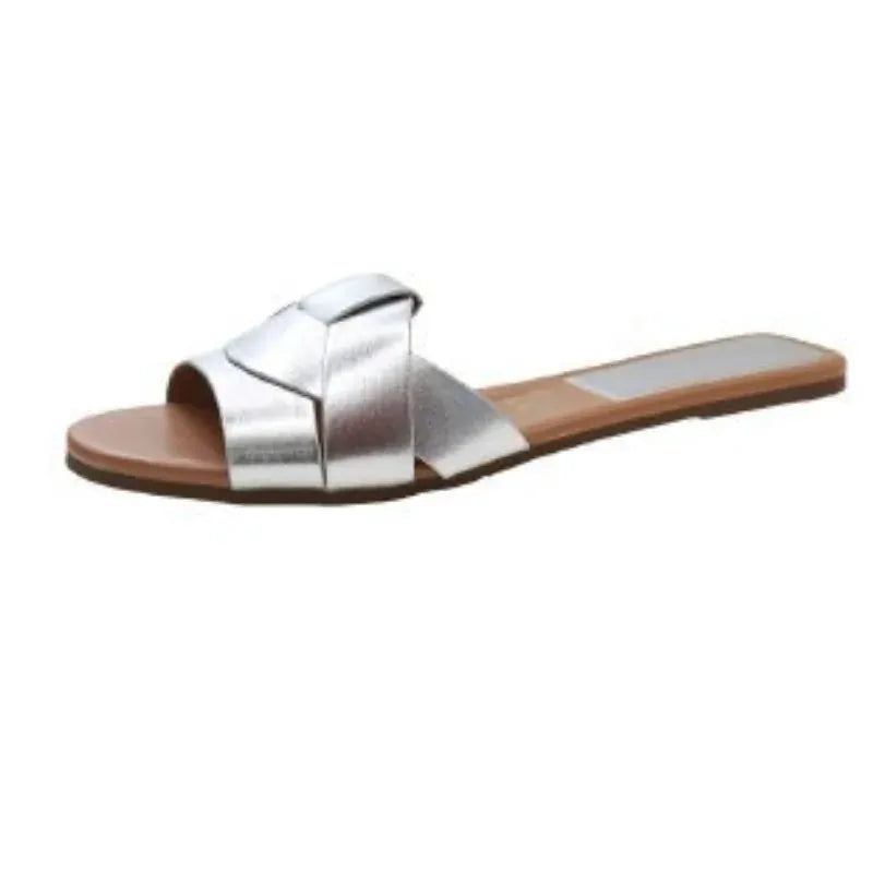 Silver cross-strap slide sandal with tan footbed and flat sole