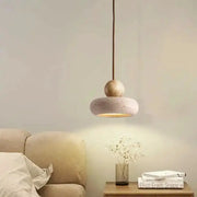 Vintage pendant light with natural yellow agate stone, hanging over a bedside table in a cozy bedroom.