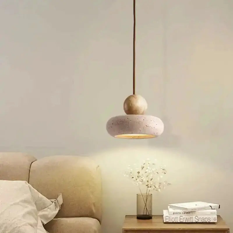 Vintage pendant light with natural yellow agate stone, hanging over a bedside table in a cozy bedroom.