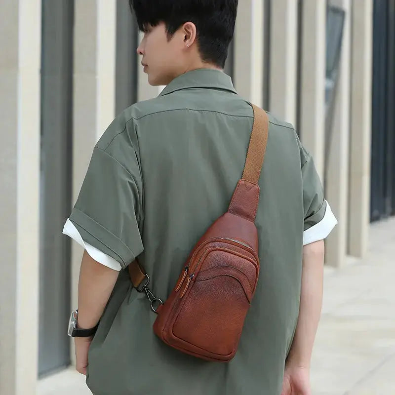 Brown genuine top-grain leather chest bag worn crossbody with two zip pockets