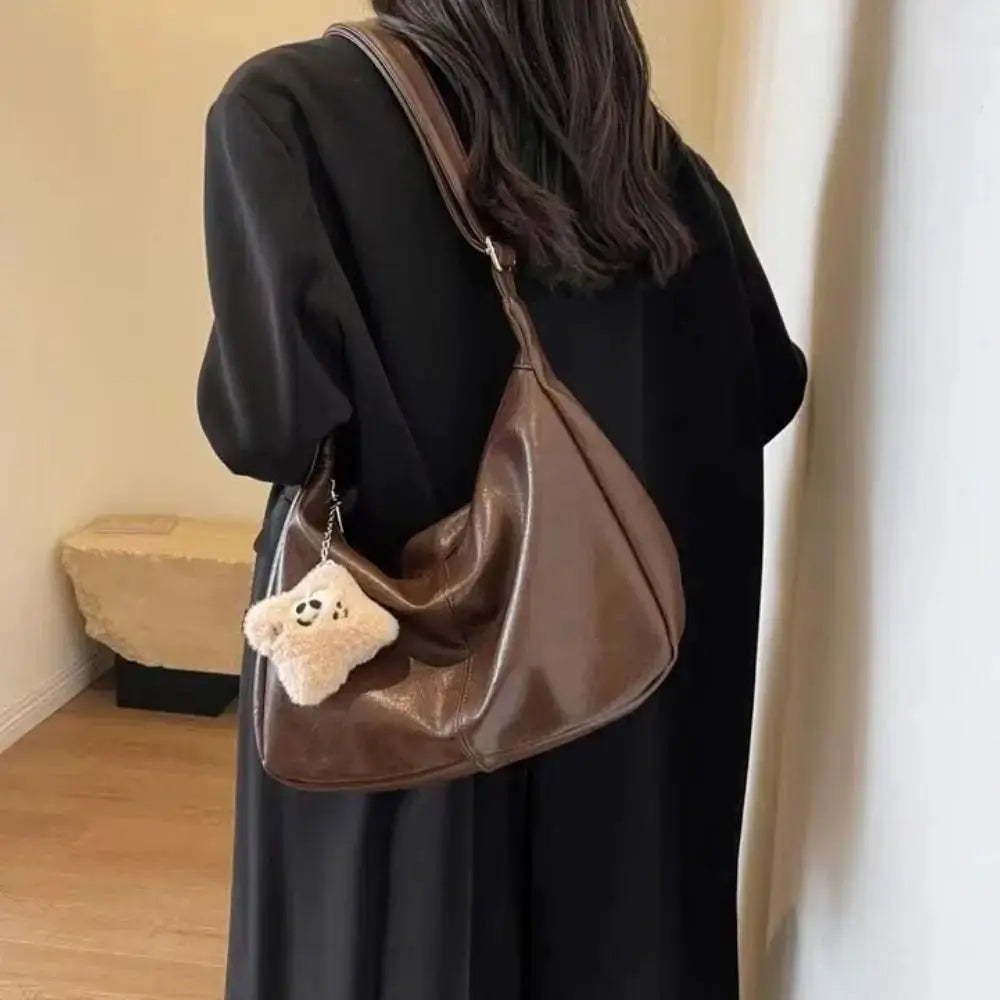 Trendy brown PU leather slouchy shoulder bag, large-capacity Simples Market hobo tote with plush keychain.