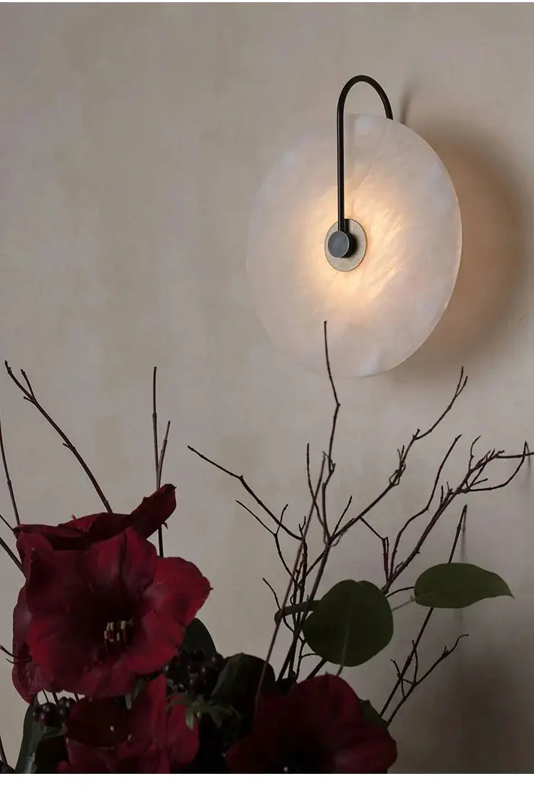 Nordic wall sconce with circular white marble moon disc and black arc arm, LED bedside light