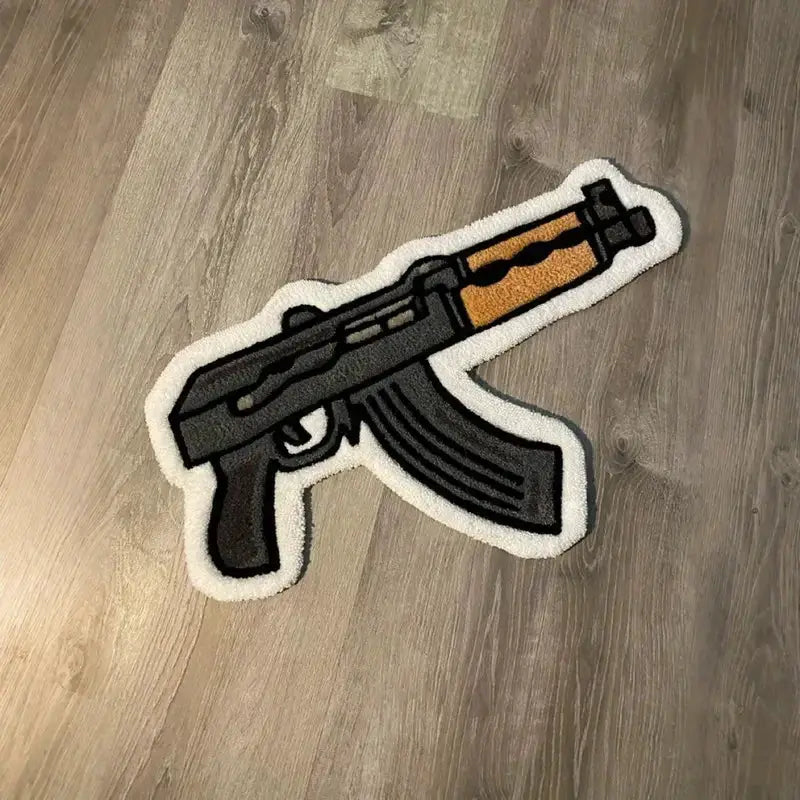 Rifle-shaped cartoon rug with black body, orange stock and white border for bedroom decor.