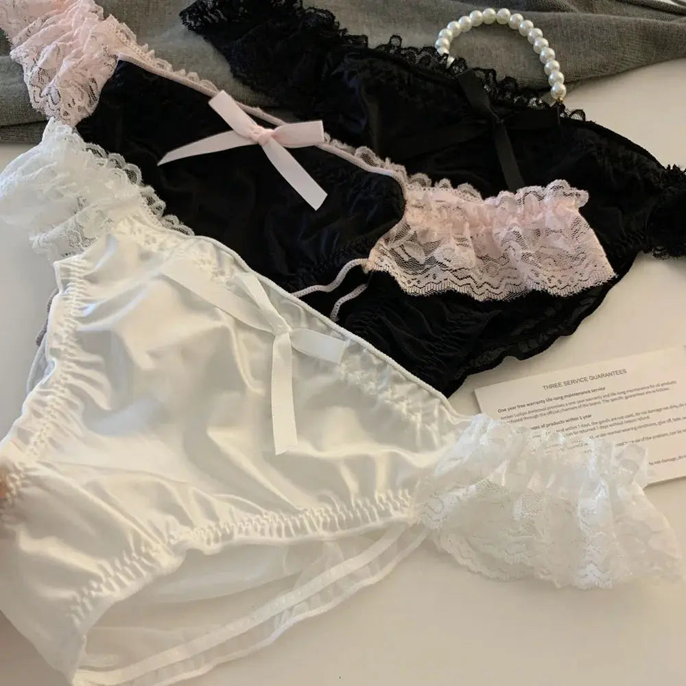 Two women's satin lace panties in white and black with bow accents and ruffle trim