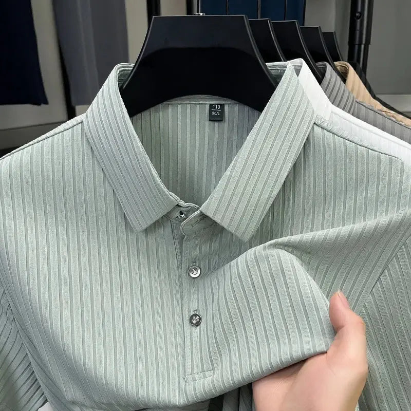 Men's striped polo shirt on hanger; pastel green vertical stripes, breathable fabric, with several pastel polos behind.