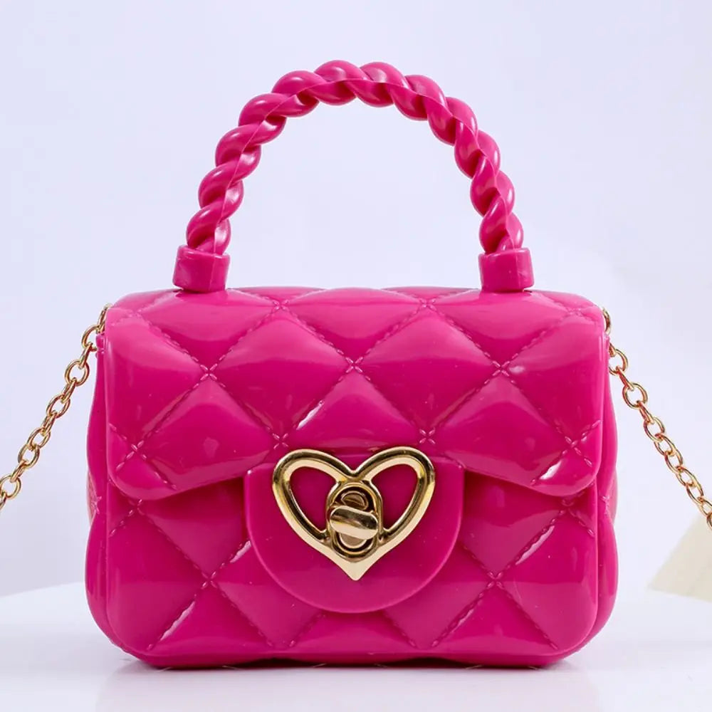 Kids pink PU leather quilted crossbody bag with braided top handle and gold heart clasp.