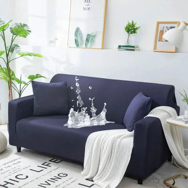 Waterproof navy stretch sofa cover on a 3-seat L-shaped couch with pillows and knit throw