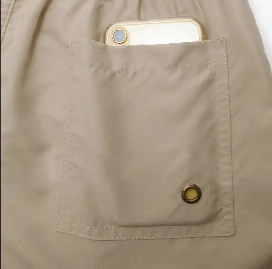 Men's beige quick-dry board shorts with patch pocket and metal grommet