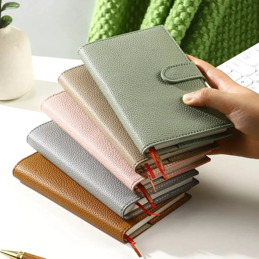 A6 weekly planner notebooks with pebble leather covers in assorted colors; set of 6.