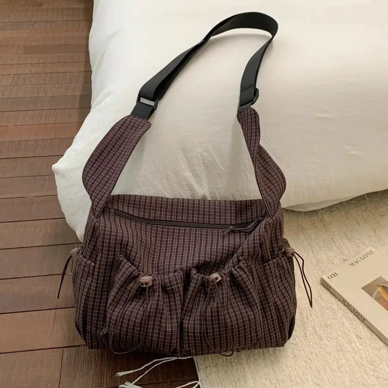 Korean nylon plaid shoulder bag with front drawstring-pleated pockets and an adjustable black strap