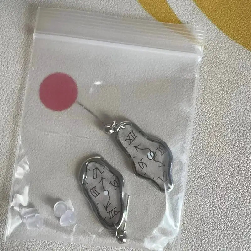 Unique Clock Earrings pair by Simples Market; irregular silver-toned metal with etched symbols
