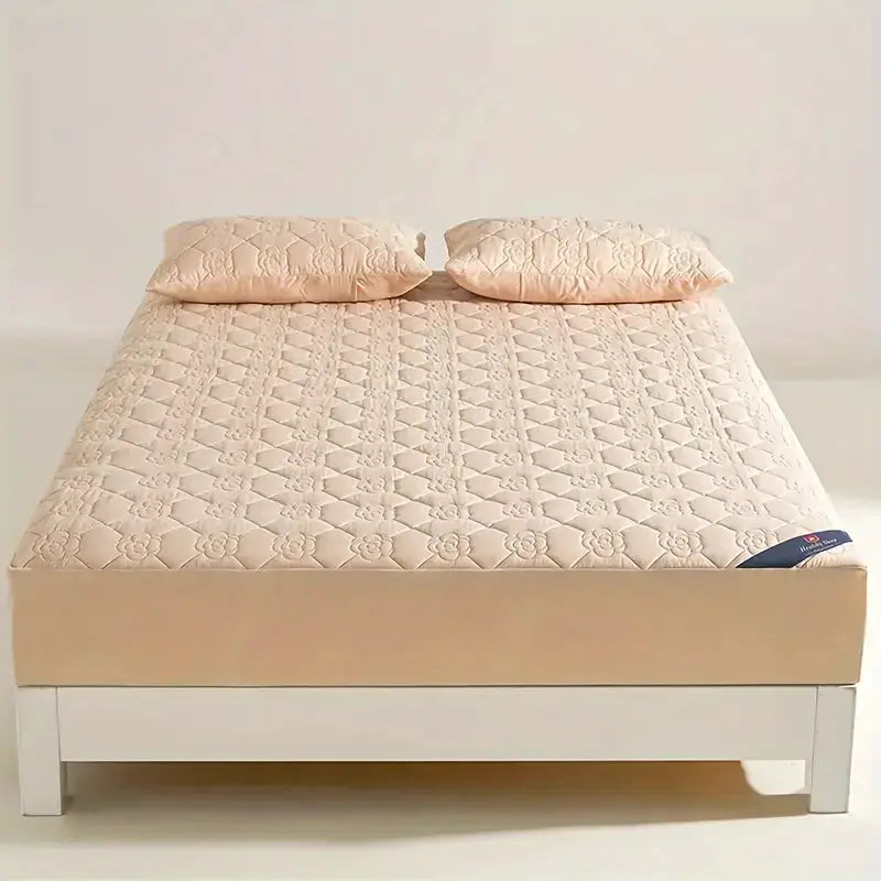 Simples Market waterproof mattress protector on a pale pink quilted fitted sheet with two pillows