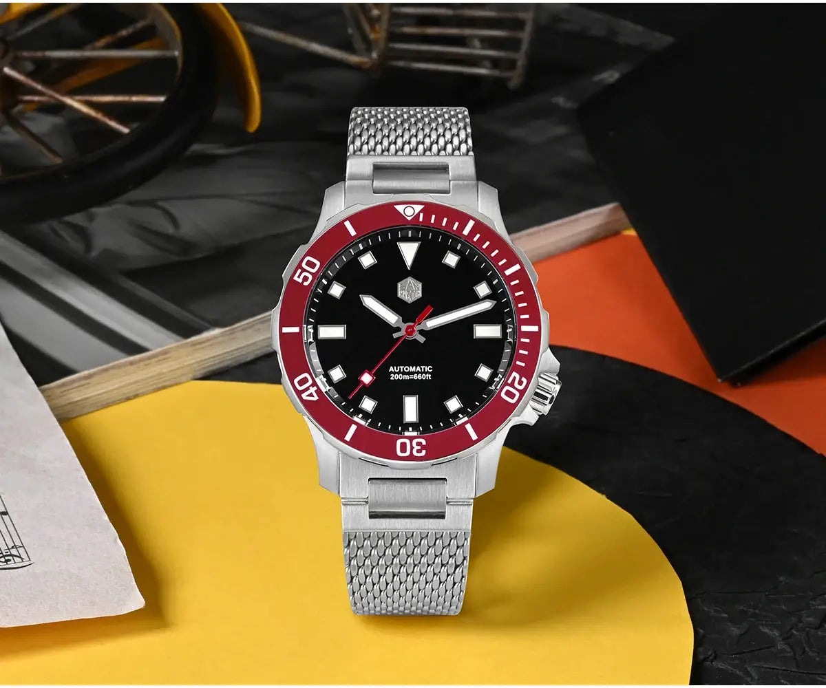 San Martin diver watch with red bezel, black dial, luminous markers, and Milanese bracelet; 200m water resistant.