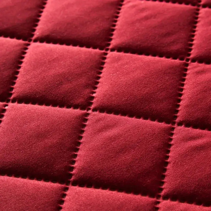 Pillowcase, red quilted cotton with square grid stitching.