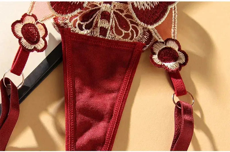 Butterfly lace thong in red with sheer mesh and embroidered floral details, adjustable waist.