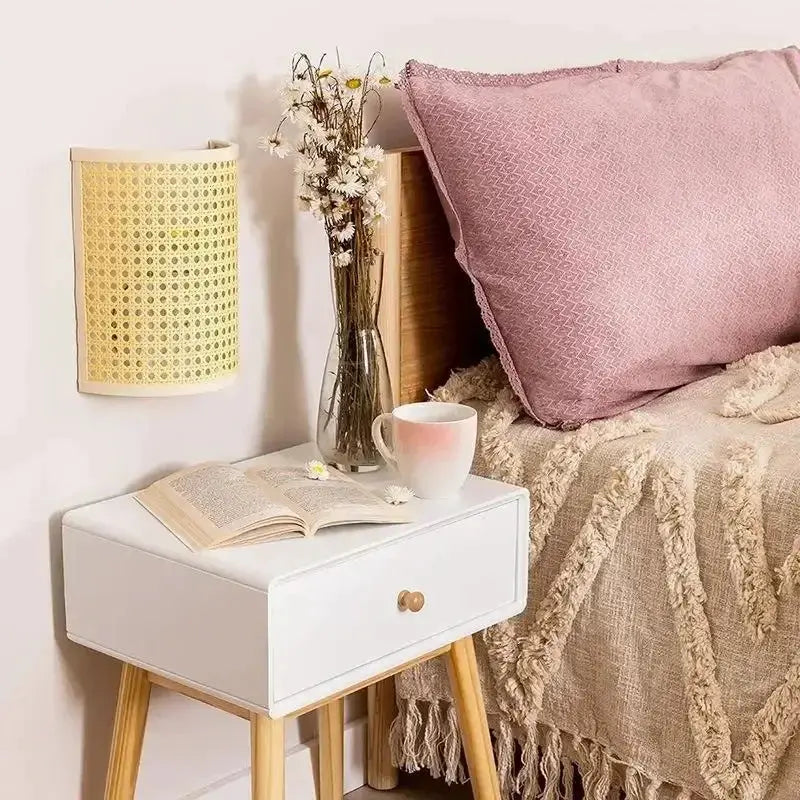 Rattan wall lamp sconce, natural beige, mounted on bedroom wall beside white nightstand