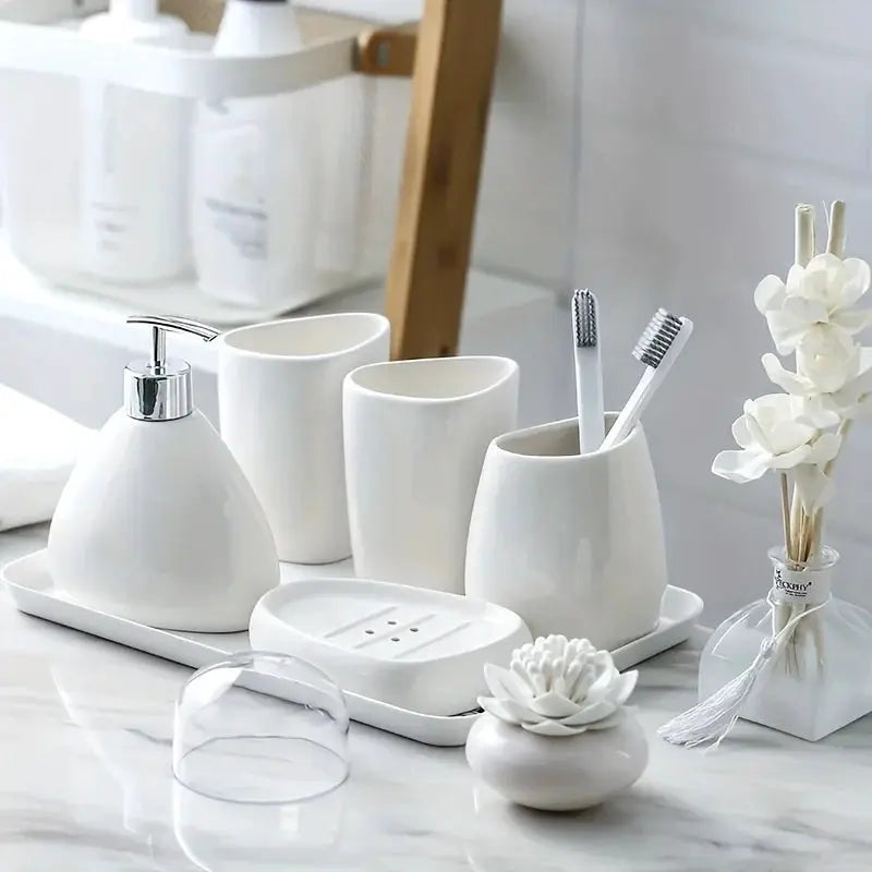 White ceramic bathroom accessory set with soap dispenser, mouthwash cup, toothbrush holder, and matching tray (4 pieces)