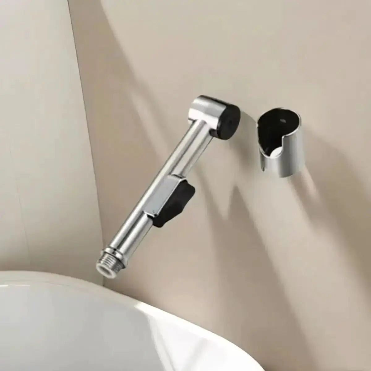 Handheld stainless steel shower spray head with adjustable angle and wall-mounted bracket.