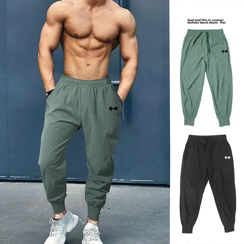 Two pairs of men's gym jogger pants in green and black with elastic waist and cuffed ankles, quick-dry fabric.
