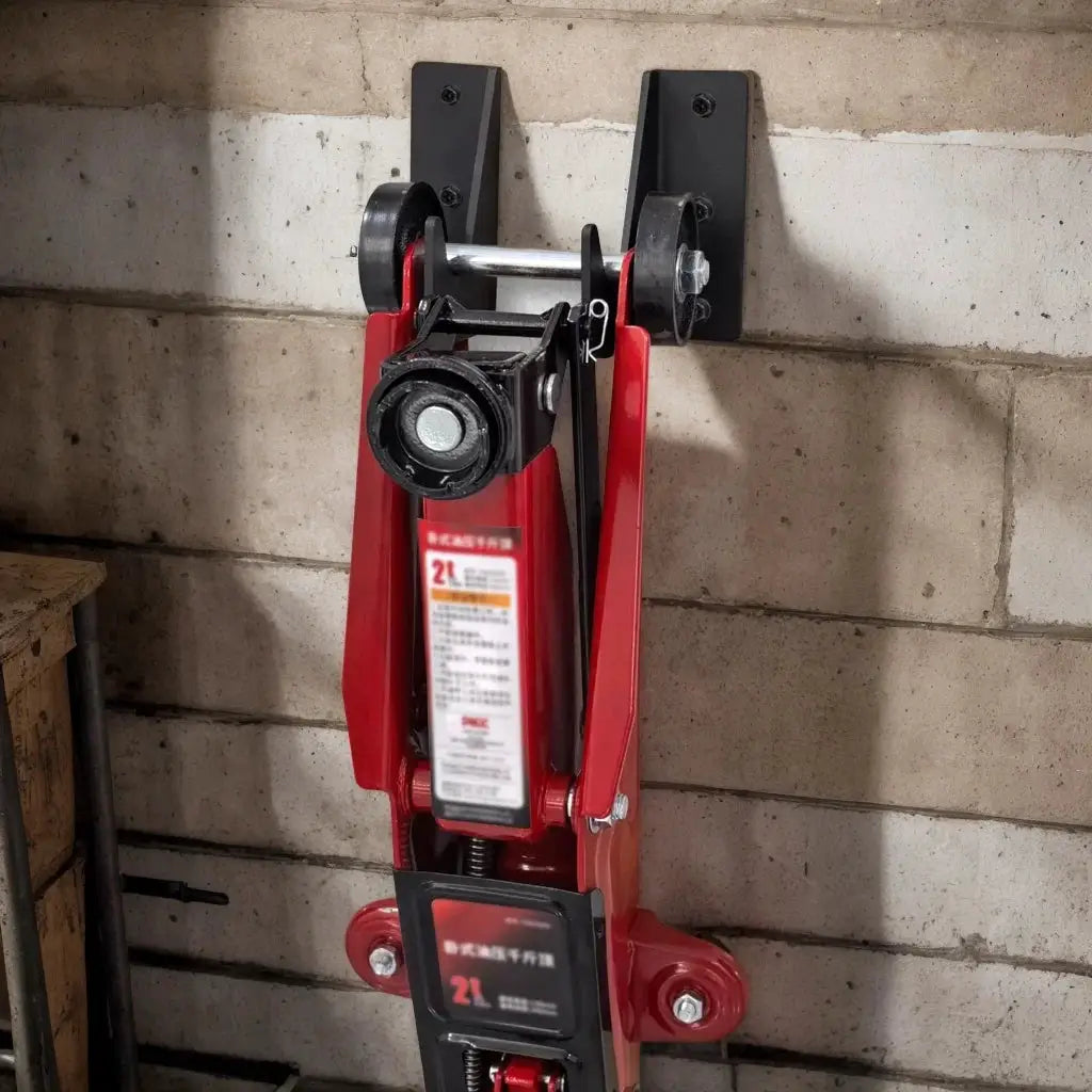 Floor jack wall-mounted storage rack by Simples Market; red hydraulic jack secured on wall brackets.