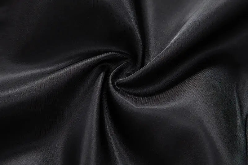 Fabric by Simples Market: black satin close-up with silky sheen, soft drape, subtle folds, rich texture.