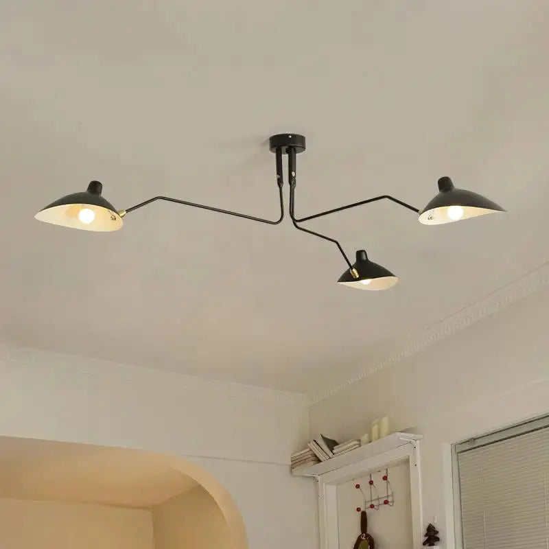 Modern Creative Spider Grabbing Pendant Light by Simples Market with four black metal arms and LED lamps