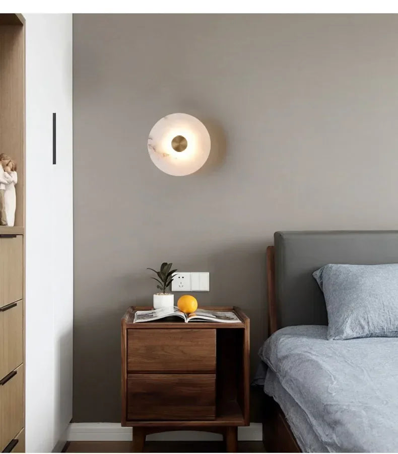 Round marble wall lamp by Simples Market with copper finish for bedside lighting