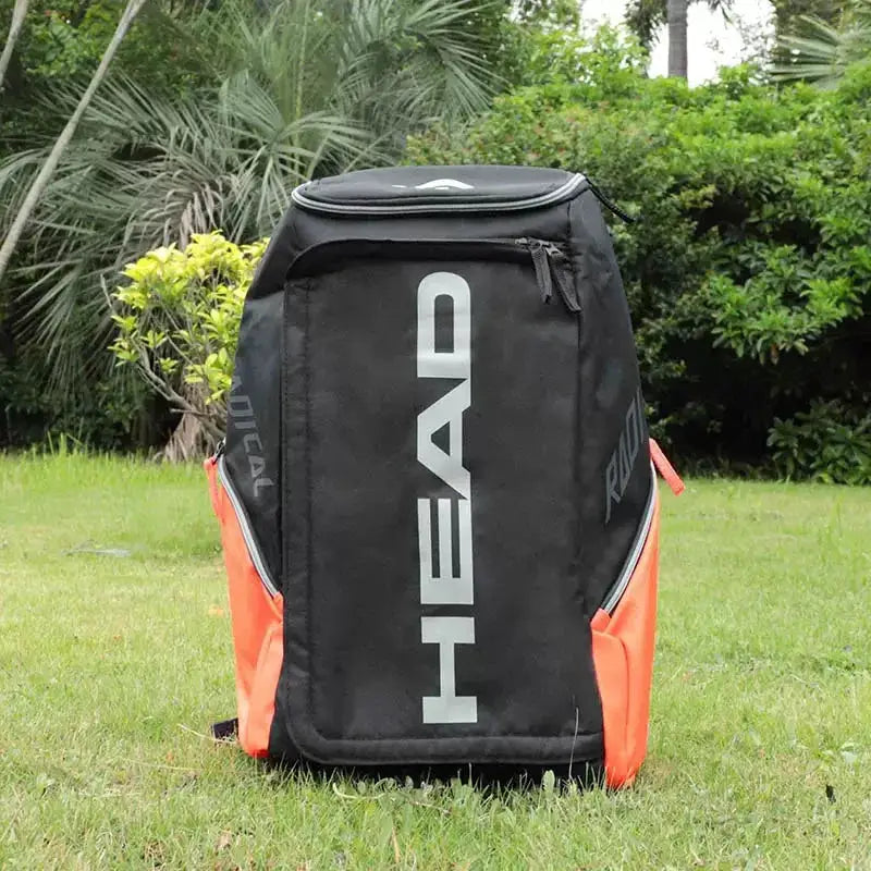 HEAD Original Radical tennis backpack in black with orange side panels and a large white HEAD logo.
