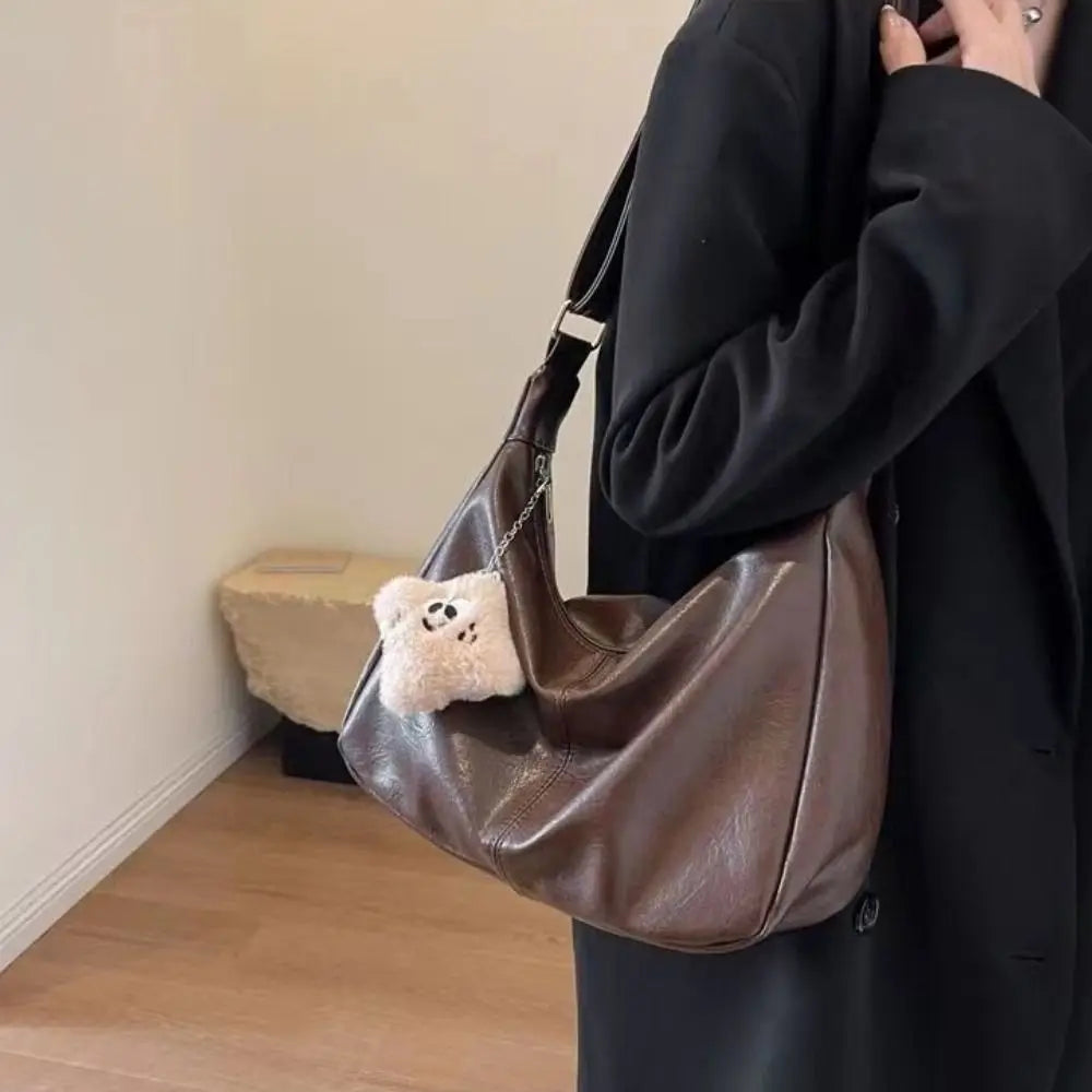 Trendy slouchy shoulder bag in brown PU leather with plush panda charm; large-capacity hobo tote
