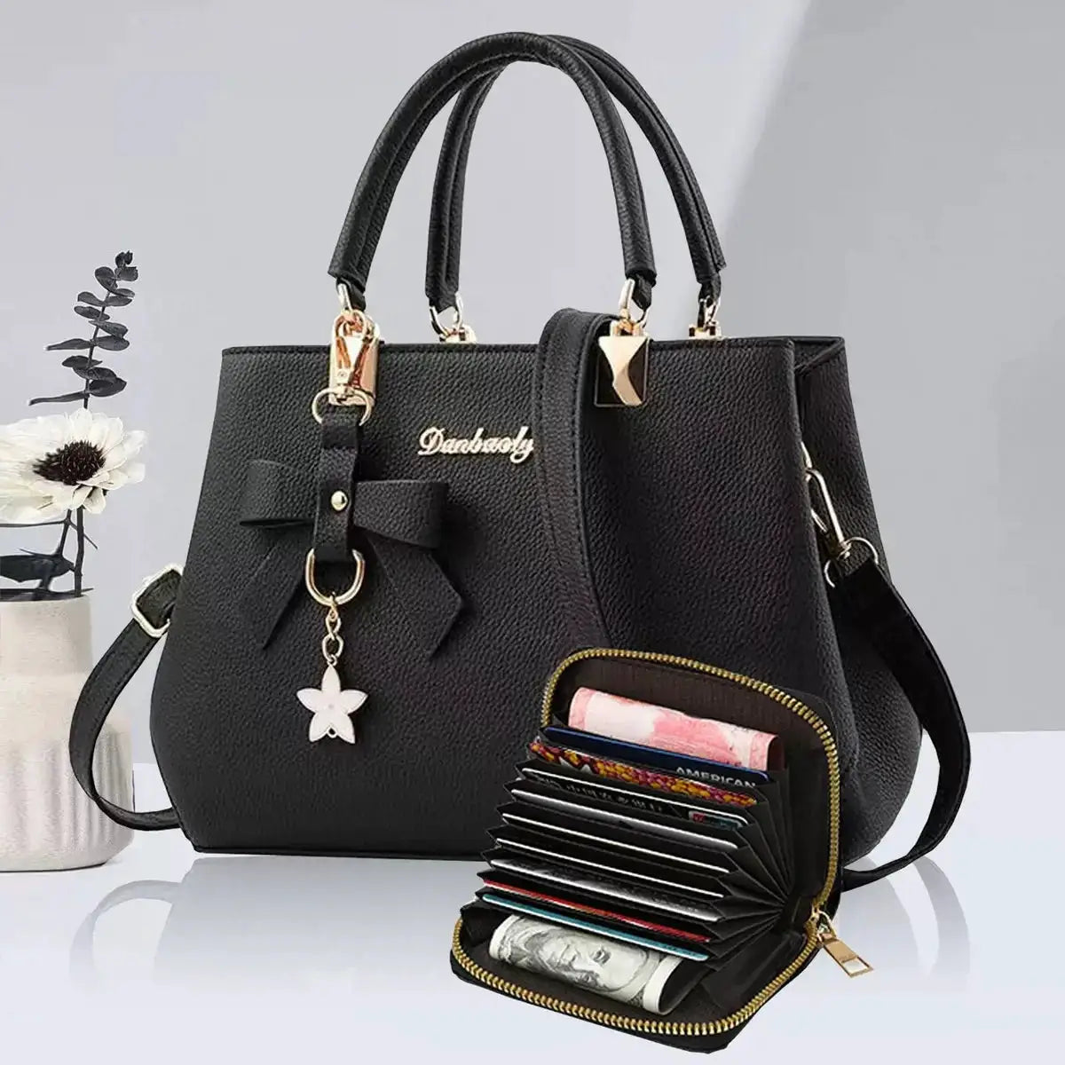 Black bow-accent women's handbag with double top handles and gold hardware; includes a multi-slot wallet.