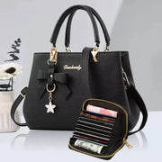 Black bow-accent women's handbag with double top handles and gold hardware; includes a multi-slot wallet.