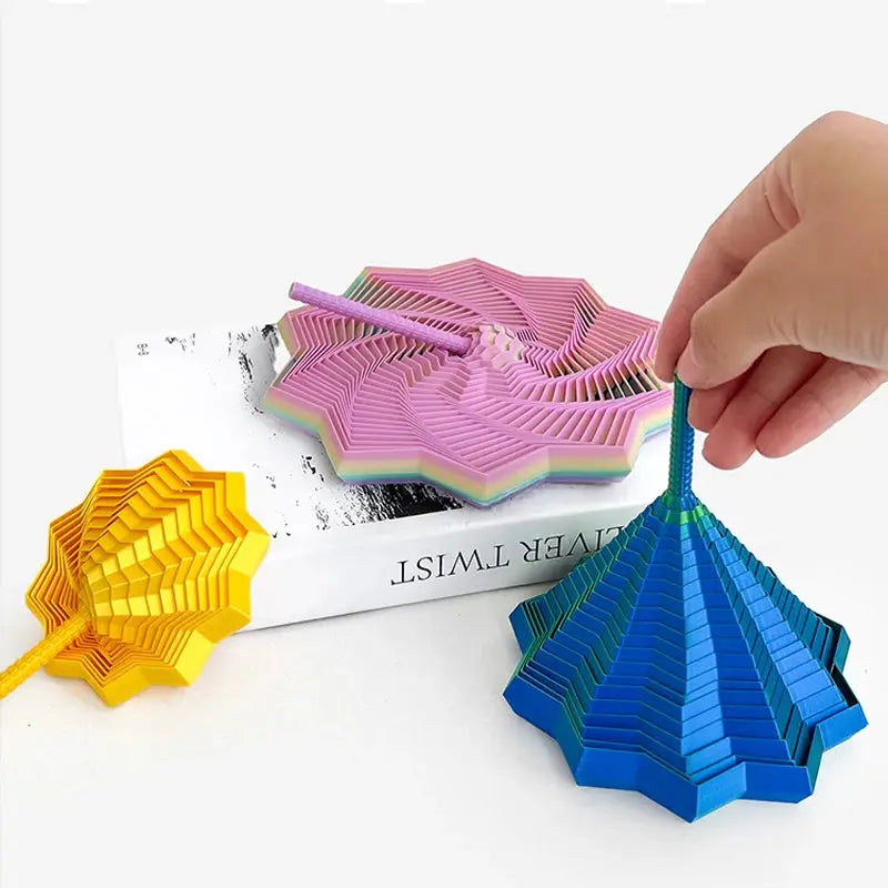 Three-piece set of 3D-printed sensory fidget star models in yellow, pink, and blue; layered hexagon spirals.