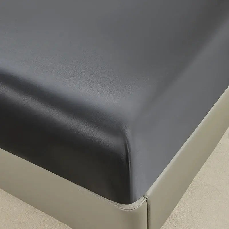 Waterproof fitted bed sheet with elastic band in charcoal black on a mattress