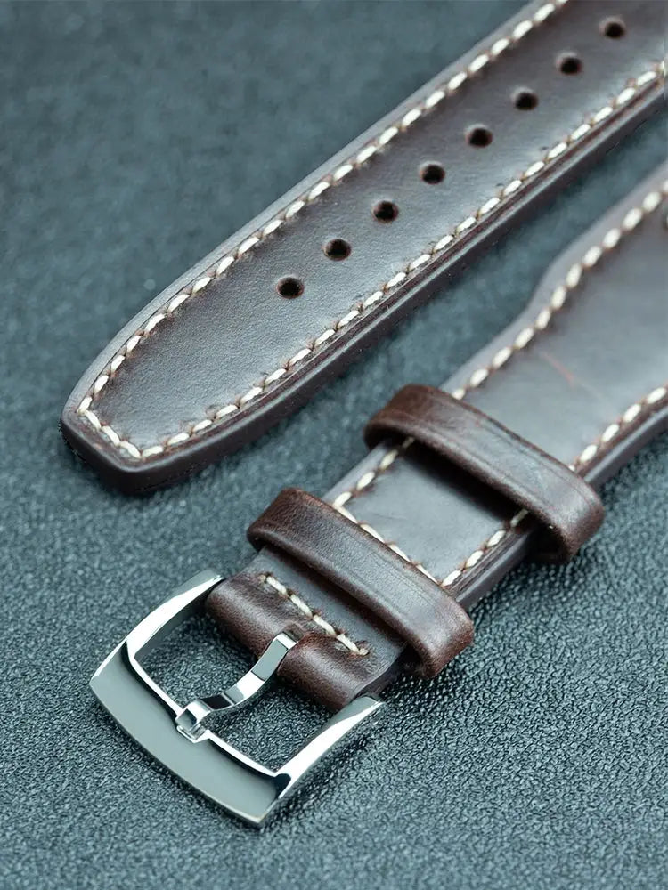 Two brown leather watch straps with white stitching and a polished stainless steel buckle