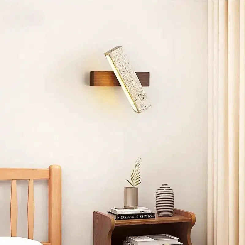 Natural stone wall lamp sconce by Simples Market with wooden mount and diagonal stone block, warm light.